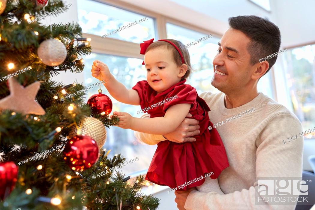 Stock Photo: happy father and baby girl decorate christmas tree.