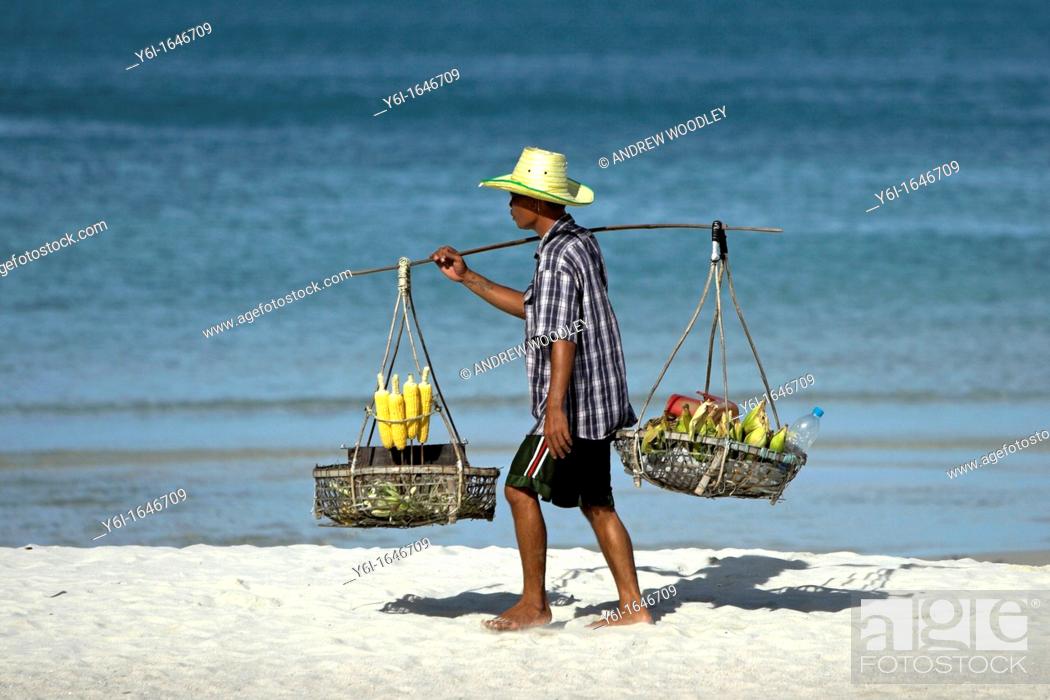 Stock Photo: Corn vendor with traditional shoulder baskets Sunrise Beach Ko Pha Ngan island Thailand.