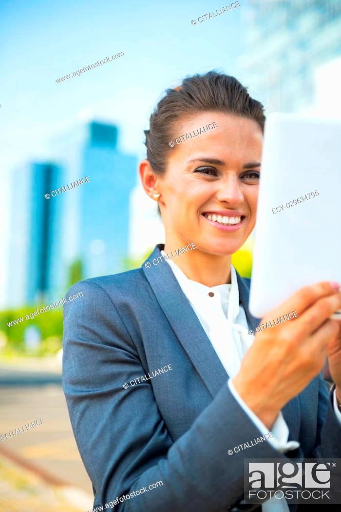 Stock Photo: Happy business woman using tablet pc in office district.