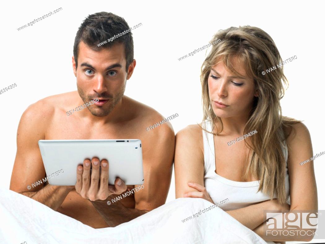 Stock Photo: angry woman while his partner is watching a tablet.
