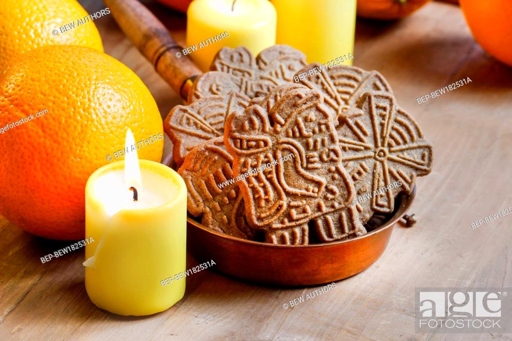 Stock Photo: Bowl of christmas cookies among aromatic oranges and yellow candles.