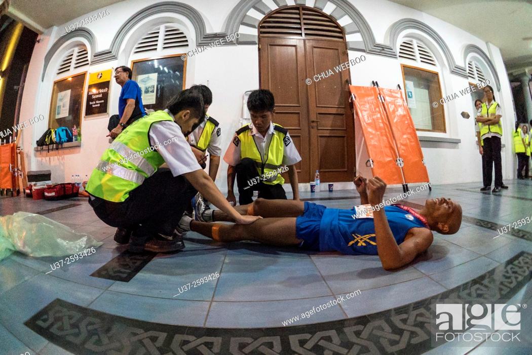 Stock Photo: First aid on marathon runner after legs cramped in Kuching, Sarawak, Malaysia.