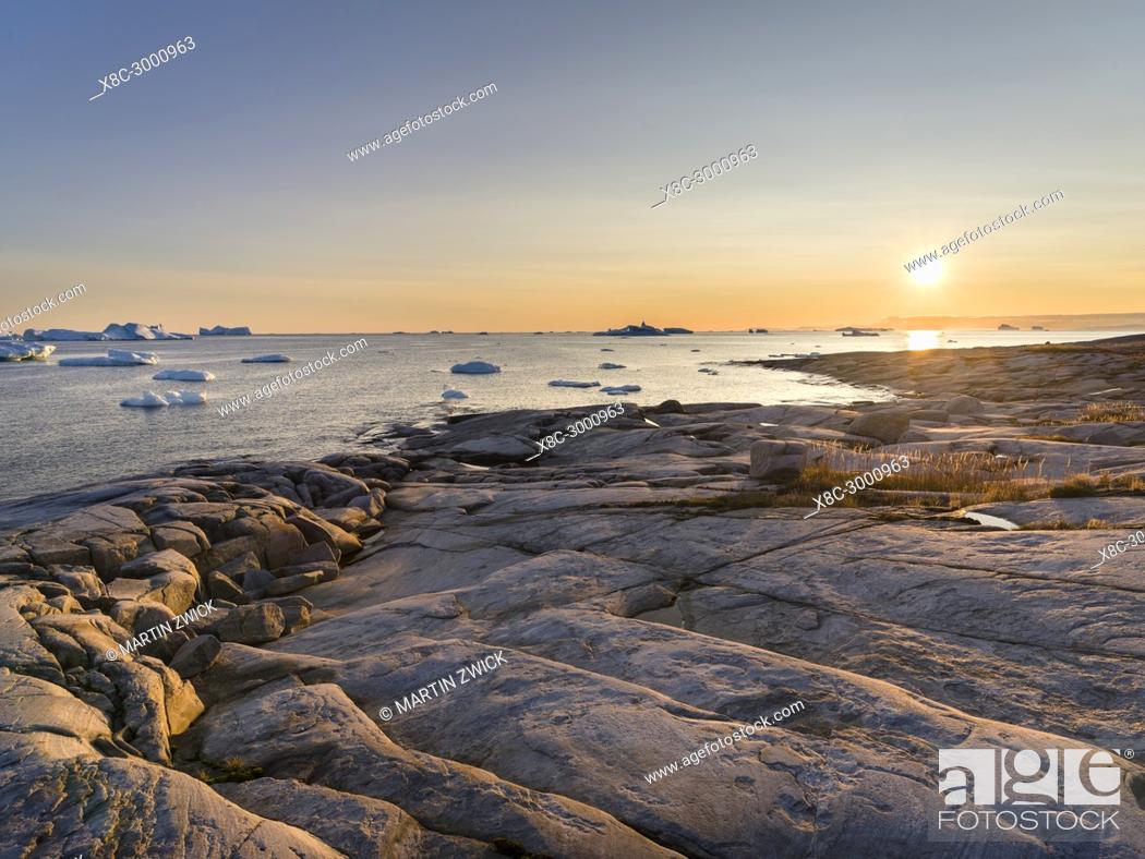 Stock Photo: Coastal landscape with Icebergs. The Inuit village Oqaatsut (once called Rodebay) located in the Disko Bay. America, North America, Greenland, Denmark.