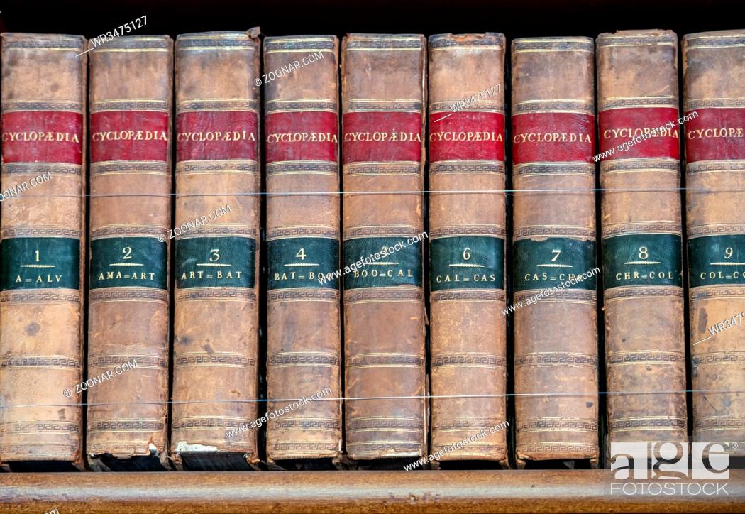 Stock Photo: Row of old leather bound encyclopaedia books on a wooden shelf.