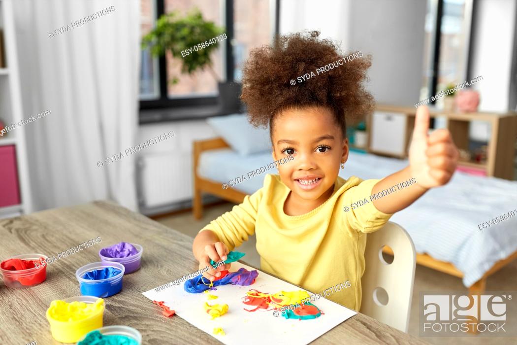 Imagen: little girl with modeling clay playing at home.