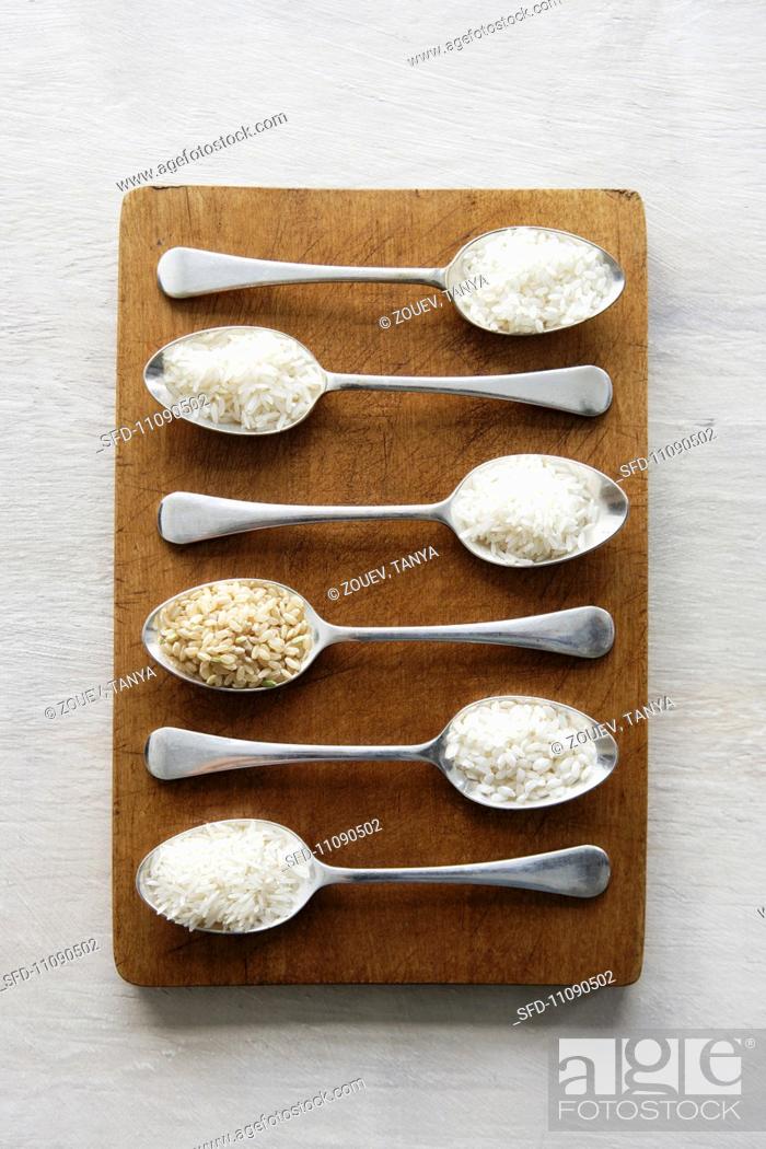 Stock Photo: Various types of rice on spoons.