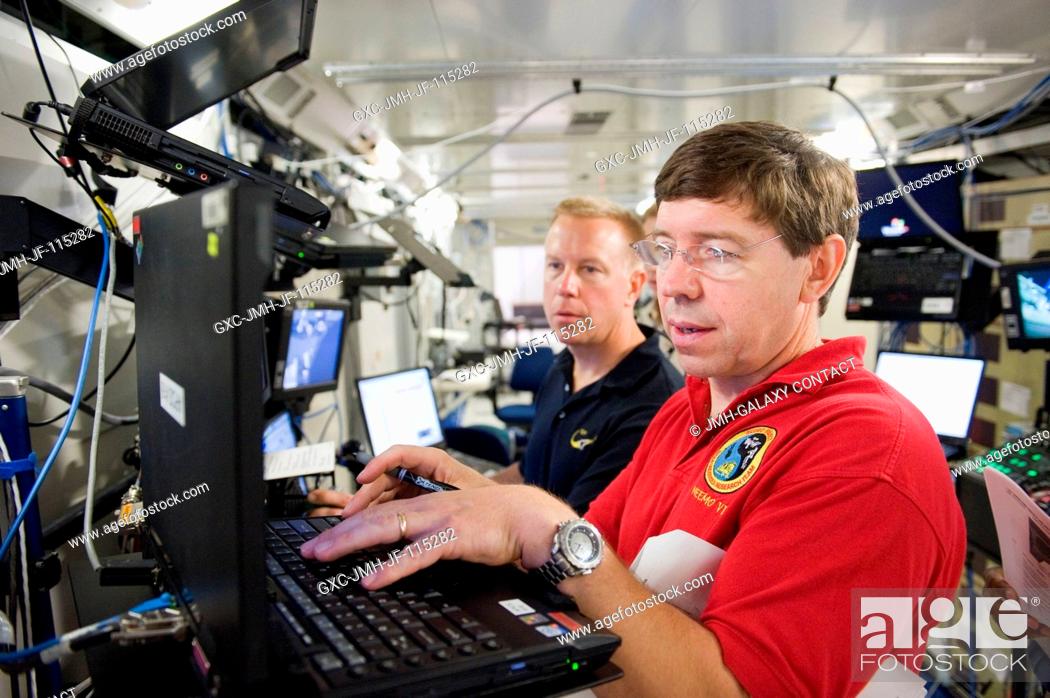 Stock Photo: NASA astronauts Michael Barratt (foreground) and Tim Kopra, both STS-133 mission specialists, participate in a robotics training session in the Jake Garn.
