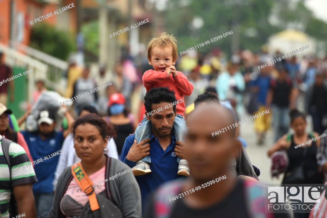 Stock Photo: 18 November 2021, Mexico, Veracruz: A man carries a young boy on his shoulders as he continues the march toward the U.S. border along with scores of migrants.