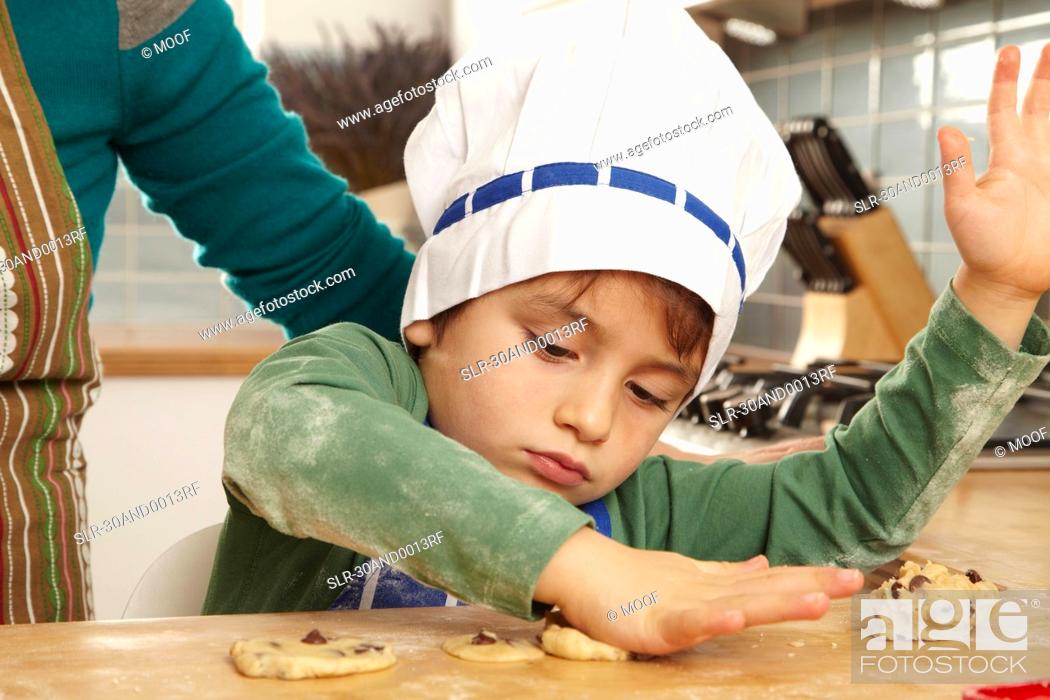 Stock Photo: Young boy making cookies in kitchen.