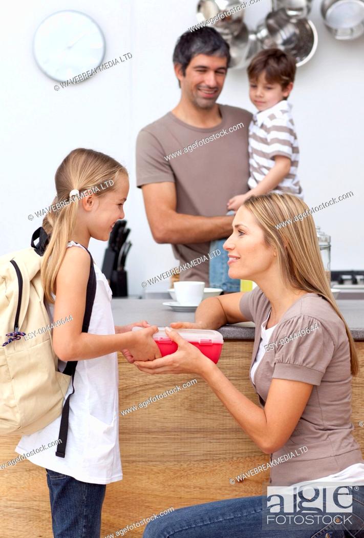 Stock Photo: Mother giving her daughter the school lunch.