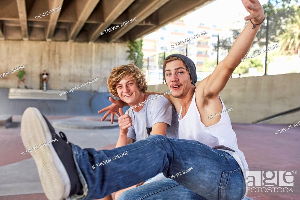 Stock Photo: Portrait enthusiastic teenage boys gesturing at skate park.