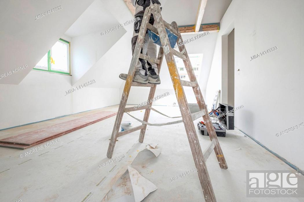 Imagen: construction site, redevelopment and renovation of an apartment, painter on a ladder in the attic.