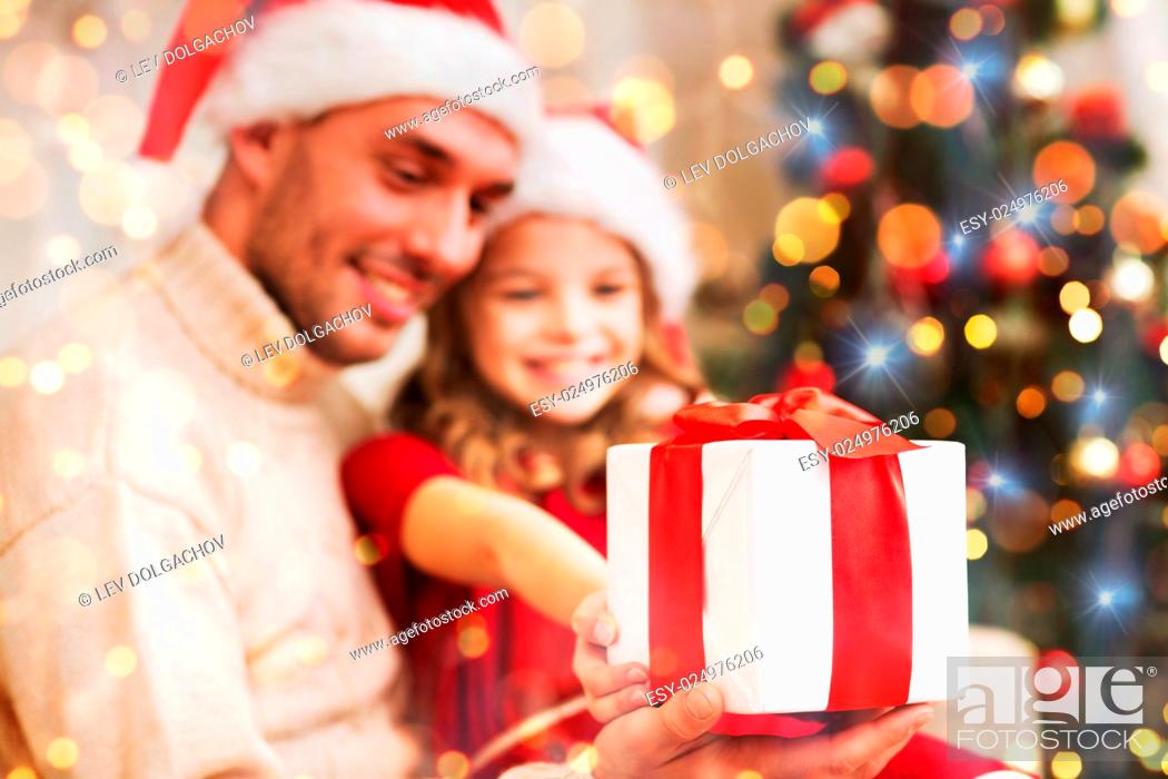 Stock Photo: family, christmas, holidays, happiness and people concept - close up of smiling daughter giving father gift box.