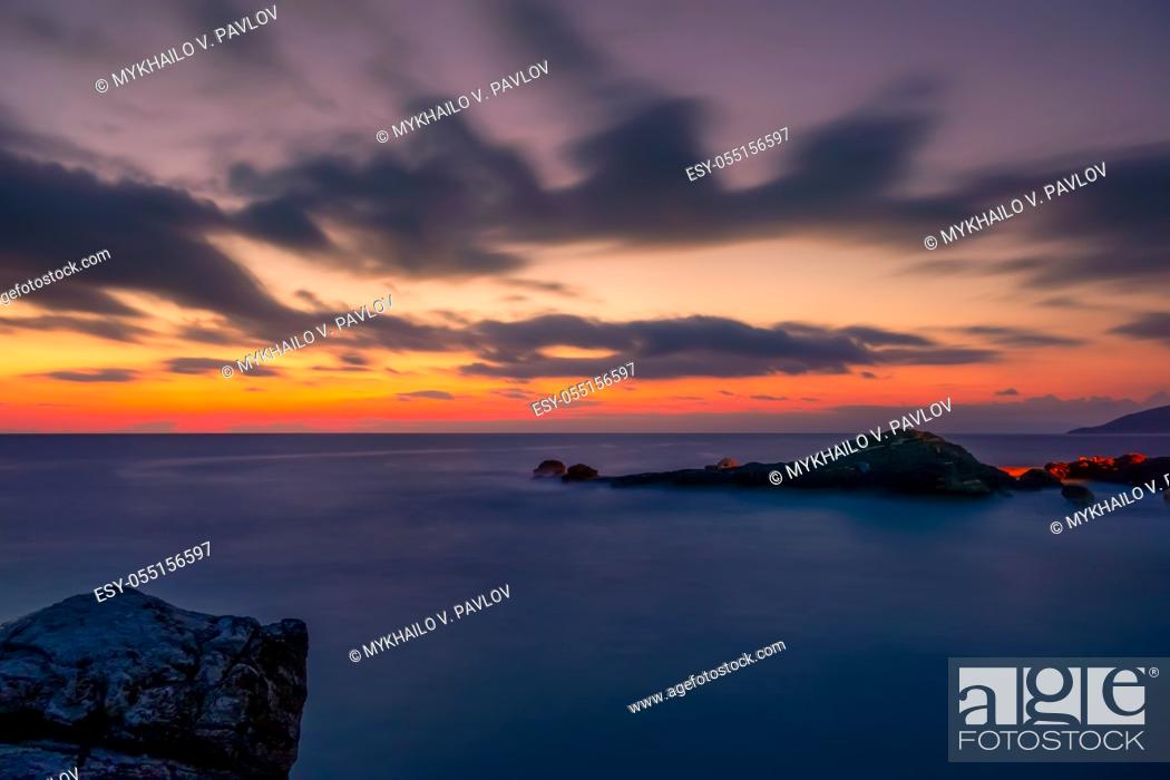 Stock Photo: Rocky shore of the sea. Colorful sunset in the sky with clouds.