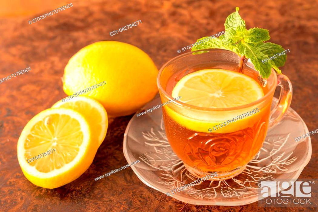 Stock Photo: Lemon Tea - Cup of lemon slices with tea and mint leaf on a rustic wooden background. Close up, Selective Focus.