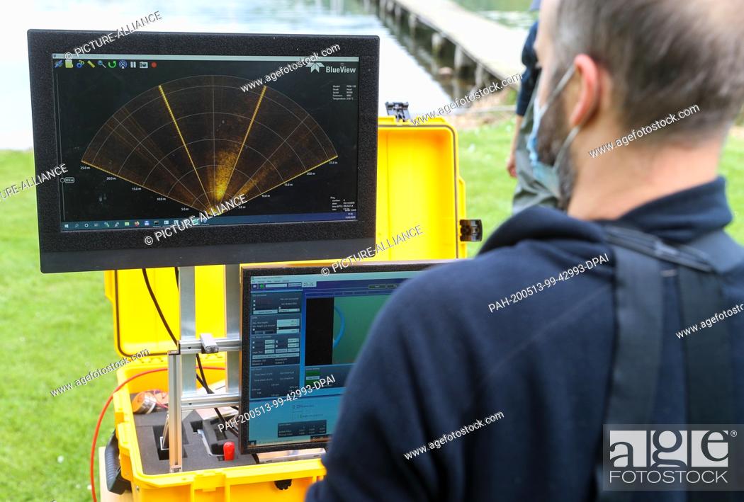 Stock Photo: 13 May 2020, Saxony-Anhalt, Seegebiet Mansfelder Land: A member of a research group steers a diving robot with a high-resolution 3D laser through the sweet lake.