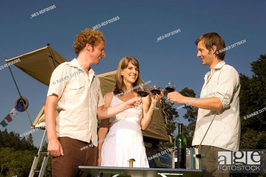 Stock Photo: Germany, Bavaria, Friends drinking red wine, smiling, portrait.