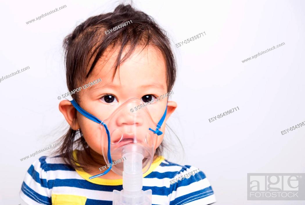 Photo de stock: Closeup Asian face, Little baby girl sick her using steam inhaler nebulizer mask inhalation oneself on white background with copy space, health medical care.