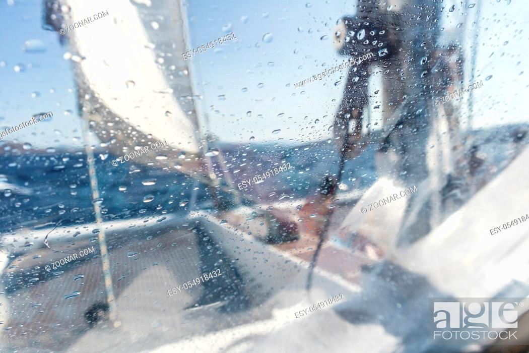 Stock Photo: Sailing yacht catamaran sailing in rough sea. Sailing. Sailboat concept. Narrow depth of field image focused on water drops on splash protective canvas.