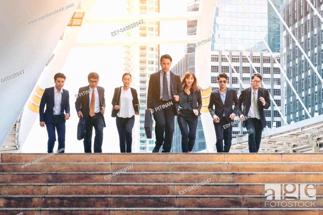 Stock Photo: Lively business team running in the city. Group of businessmen and businesswomen. Teamwork, togetherness, liveliness, business concept.