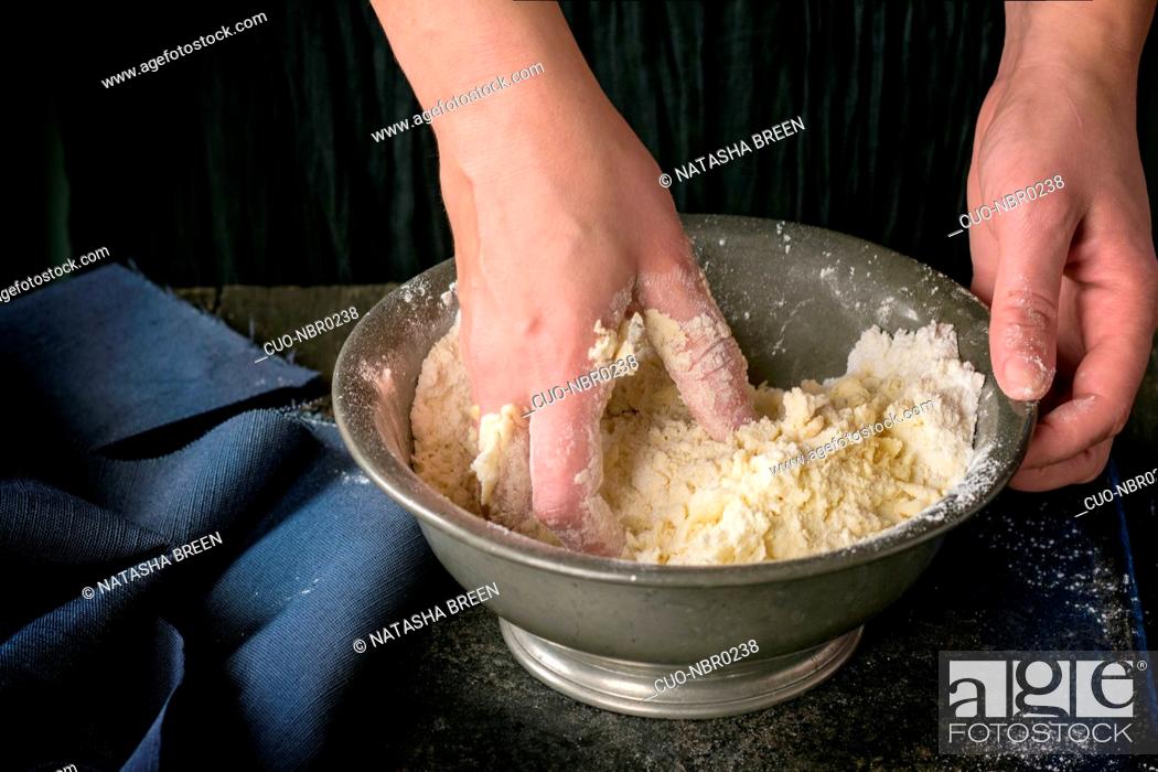 Stock Photo: Making shortcrust pastry dough by woman's hands in vintage metal bowl over old wooden table. Dark rustic style.