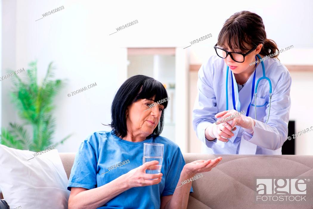 Young Doctor Visiting Old Mature Woman For Check Up Stock Photo