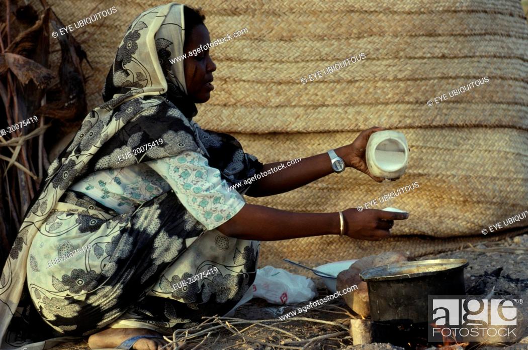 Stock Photo: Beja nomad woman cooking mededa gruel made from sorghum over open fire.