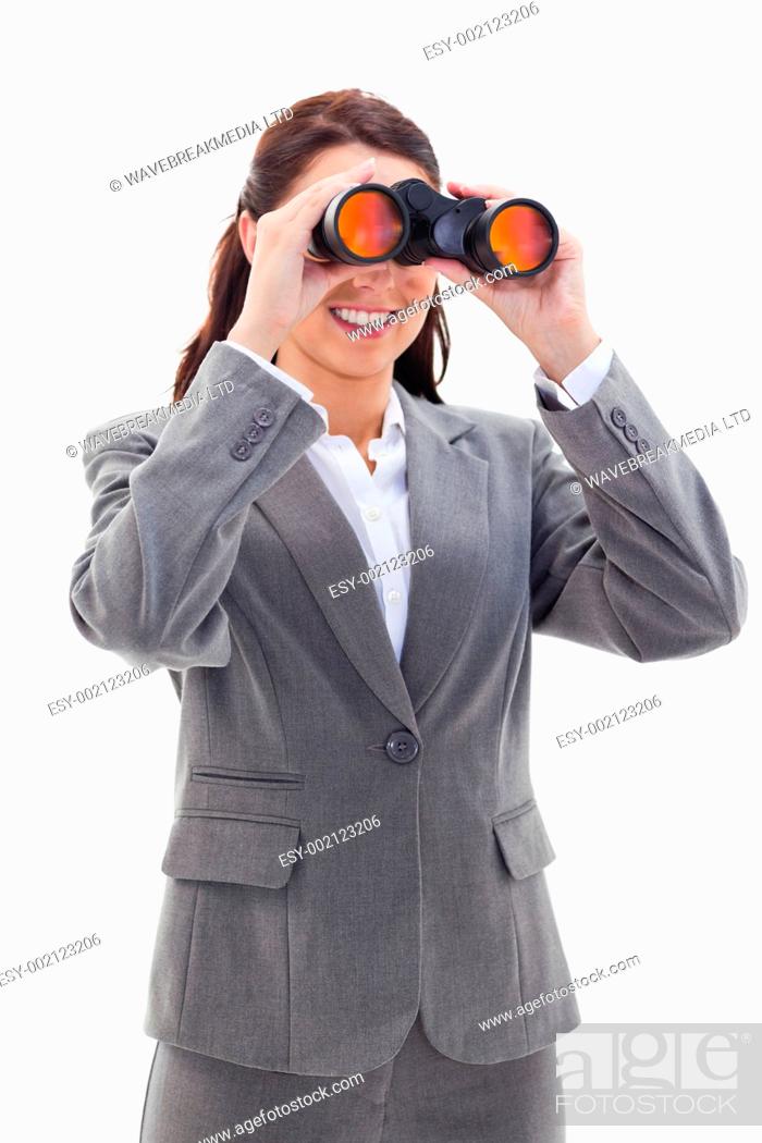 Stock Photo: Close-up of a businesswoman smiling and looking through binoculars on the left side against white background.