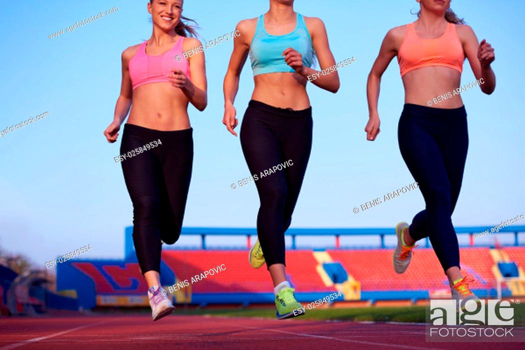 Stock Photo: athlete woman group running on athletics race track on soccer stadium and representing competition and leadership concept in sport.