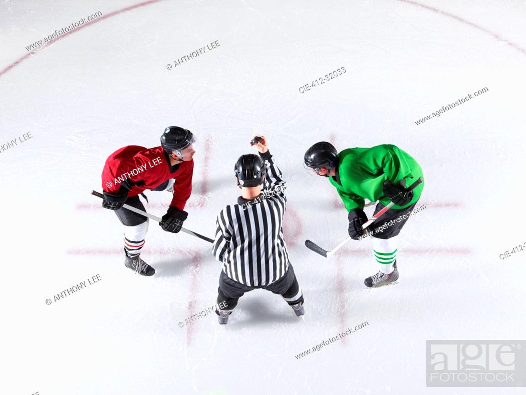 Imagen: Hockey referee initiating opening face off between opponents.