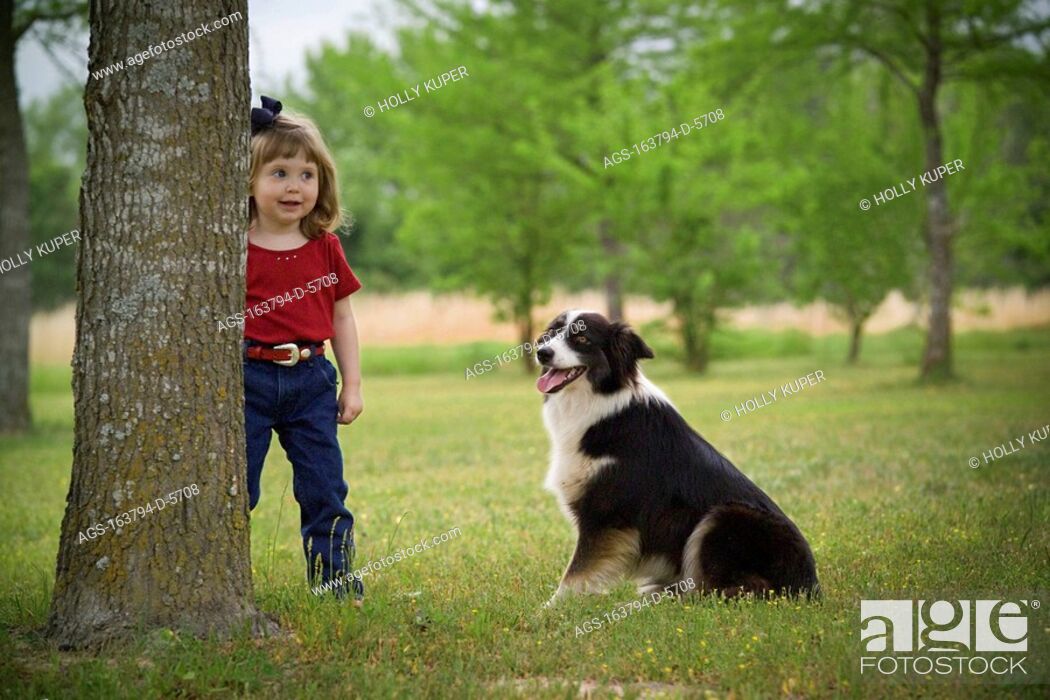 Stock Photo: Agriculture - A little ranch girl plays with her Australian Shepherd dog in the yard of her familyÕs home / TX - Tennessee Colony.