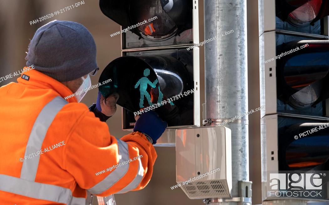 Stock Photo: 28 May 2020, Lower Saxony, Hanover: A technician installs one of the three new signal discs with different couples (lesbian.