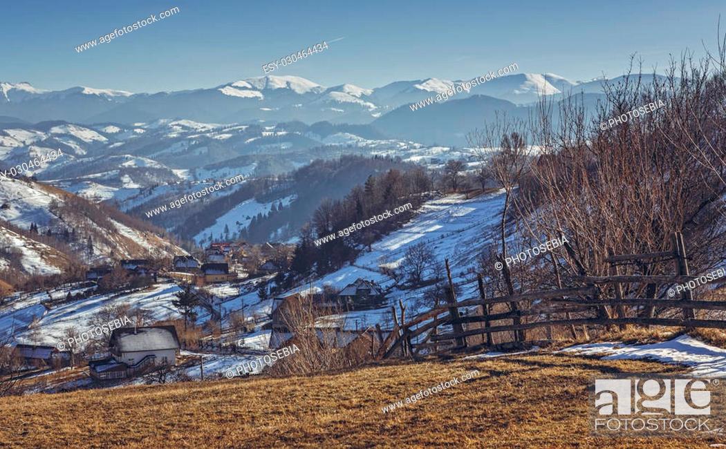 Stock Photo: Rural scenery with traditional Romanian hamlet during first snow on a sunny winter morning in Magura village, Brasov county, Transylvania region, Romania.