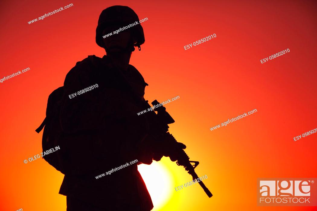Stock Photo: Silhouette of army special forces rifleman, Marines, coast guard or anti-terrorist squad soldier in ammunition and helmet, armed service rifle.