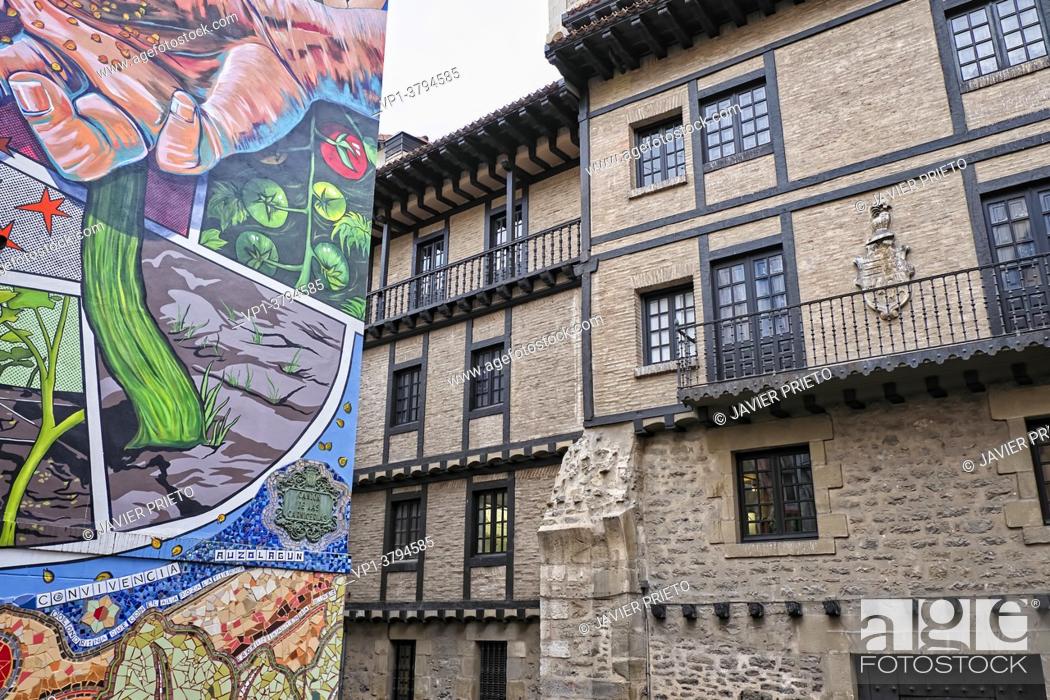 Stock Photo: Facade decorated with an artistic mural in front of a facade of a historic building. Contrast between the modern and the old.