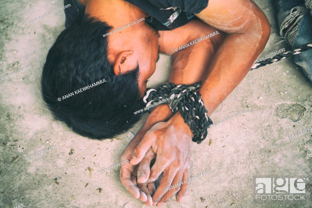 Stock Photo: hopeless man hands tied together with rope, human trafficking.