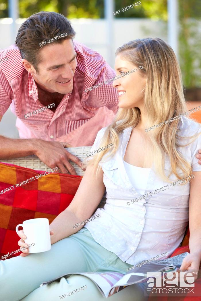 Stock Photo: Portrait Of Couple Relaxing On Outdoor Seat.