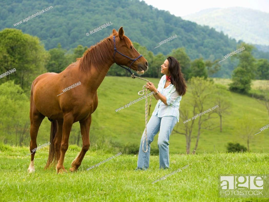 Stock Photo: woman holding the reins of a horse.