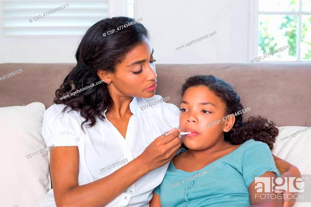 Stock Photo: Concerned mother taking her daughters temperature.