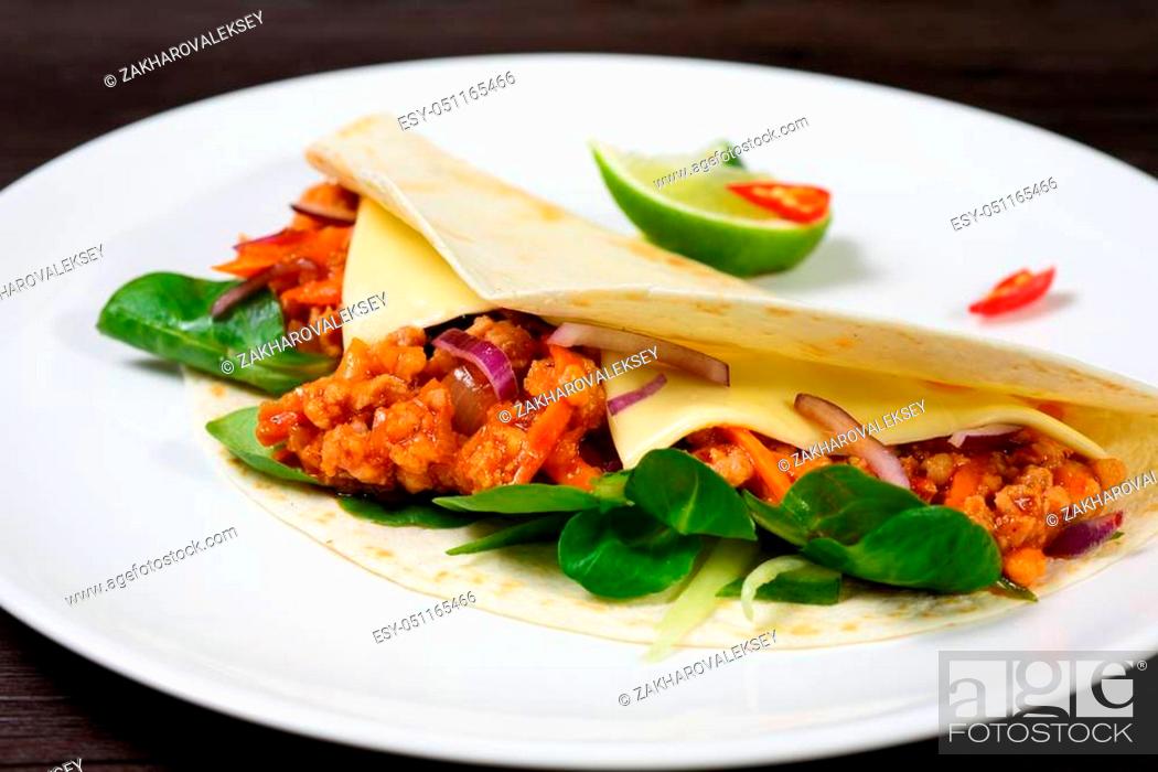 Stock Photo: Tacos on a white plate on a dark background Board is served with lime.