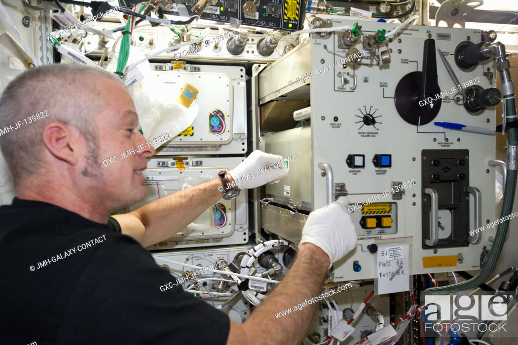 Stock Photo: NASA astronaut Steve Swanson, Expedition 40 commander, replaces filters in the Potable Water Dispenser (PWD) in the Destiny laboratory of the International.