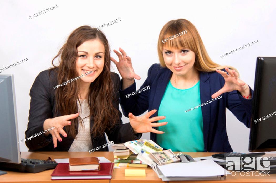 Stock Photo: for office table two women collaborators are thrown on a pile of money.