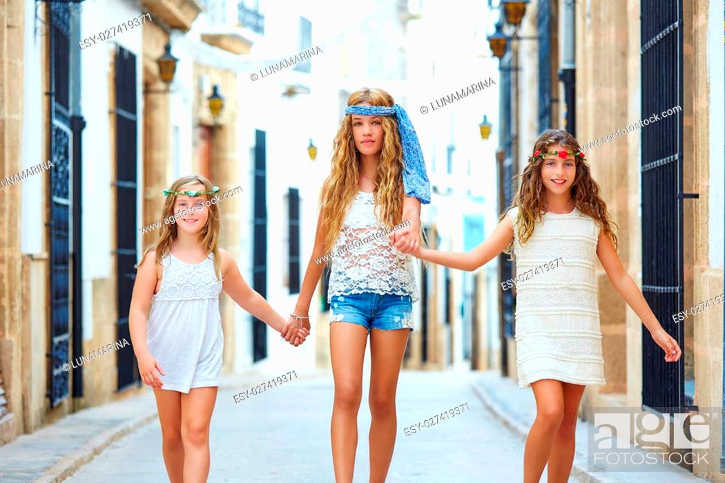 Stock Photo: Kid girls walking hand in hand at white Mediterranean village of Spain.
