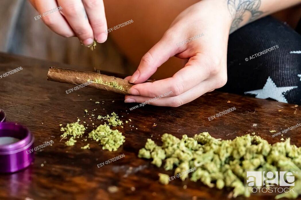 Stock Photo: A beautiful brunette model smokes marijuana in the privacy of her own home.