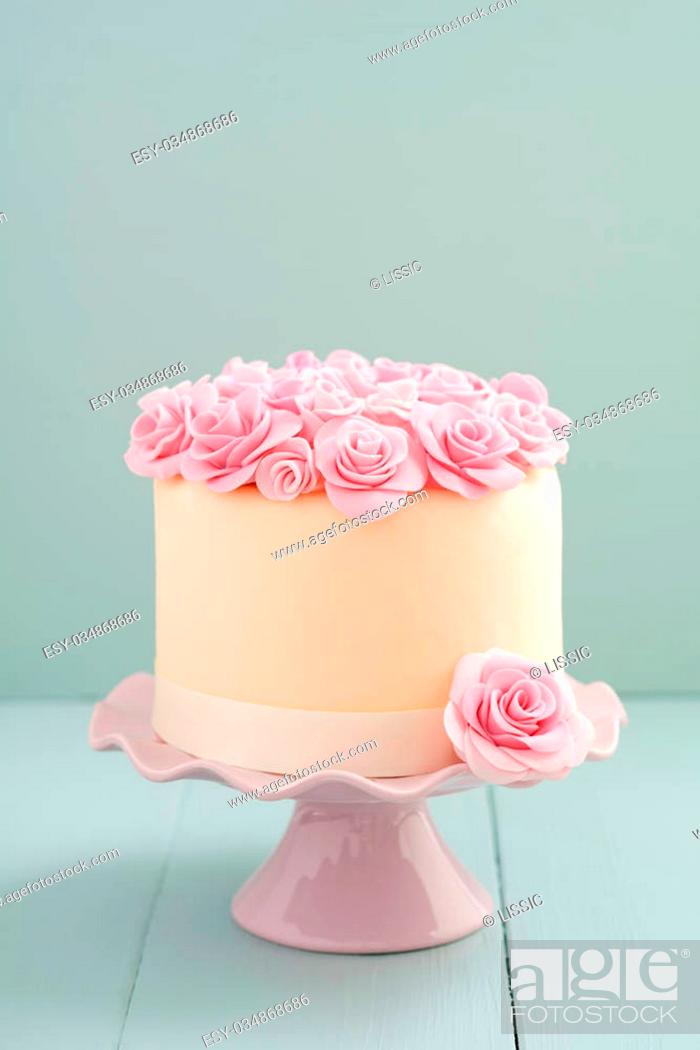 Stock Photo: Ivory fondant covered cake with pink sugar roses on cake stand.