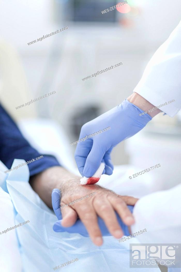 Stock Photo: Nurse cleaning patient hand from IV drip.