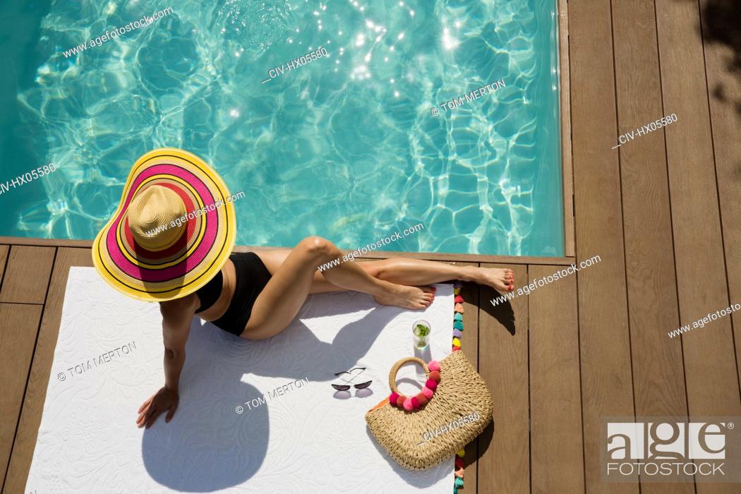 Stock Photo: Woman in sun hat sunbathing, relaxing at sunny summer poolside.