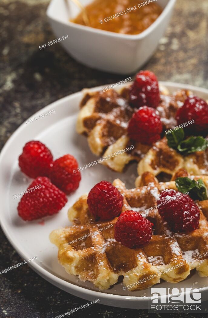 Photo de stock: Waffle with cream raspberries and chocolate strawberries. Homemade.