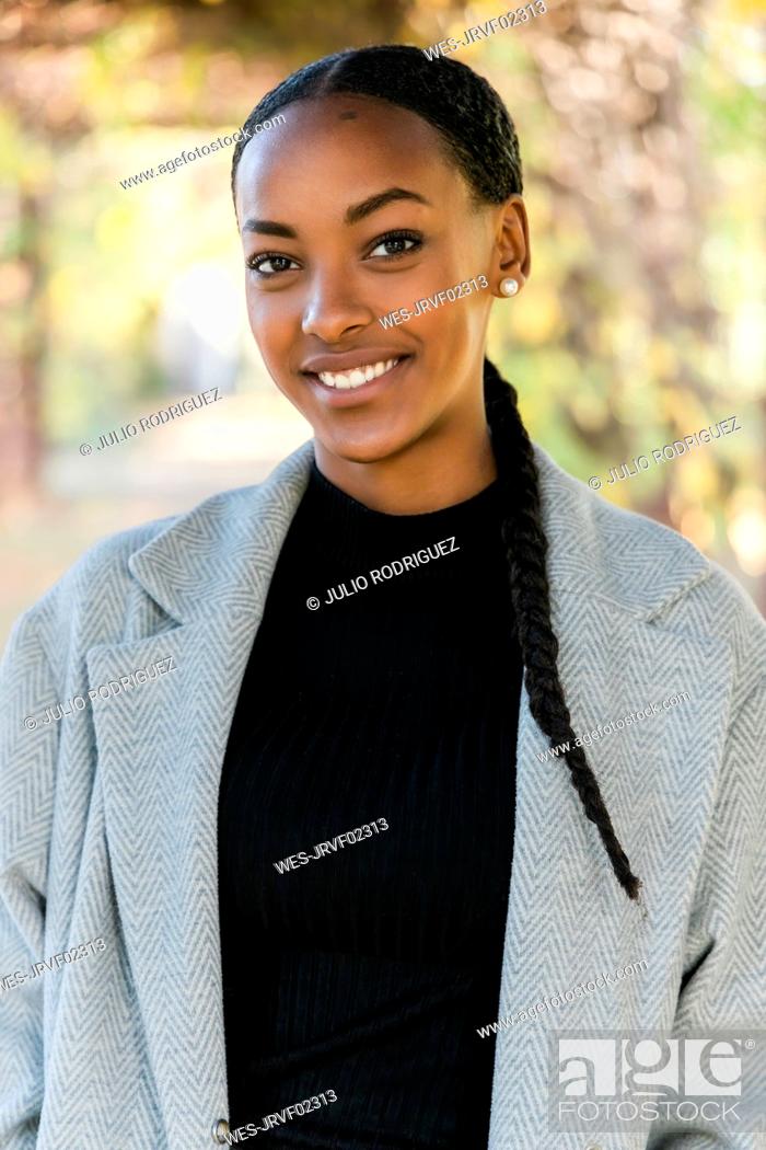 Stock Photo: Beautiful teenage girl smiling wearing trench coat.