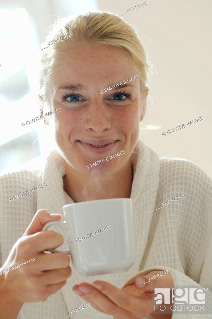 Stock Photo: Young woman with dressing and coffee mug.